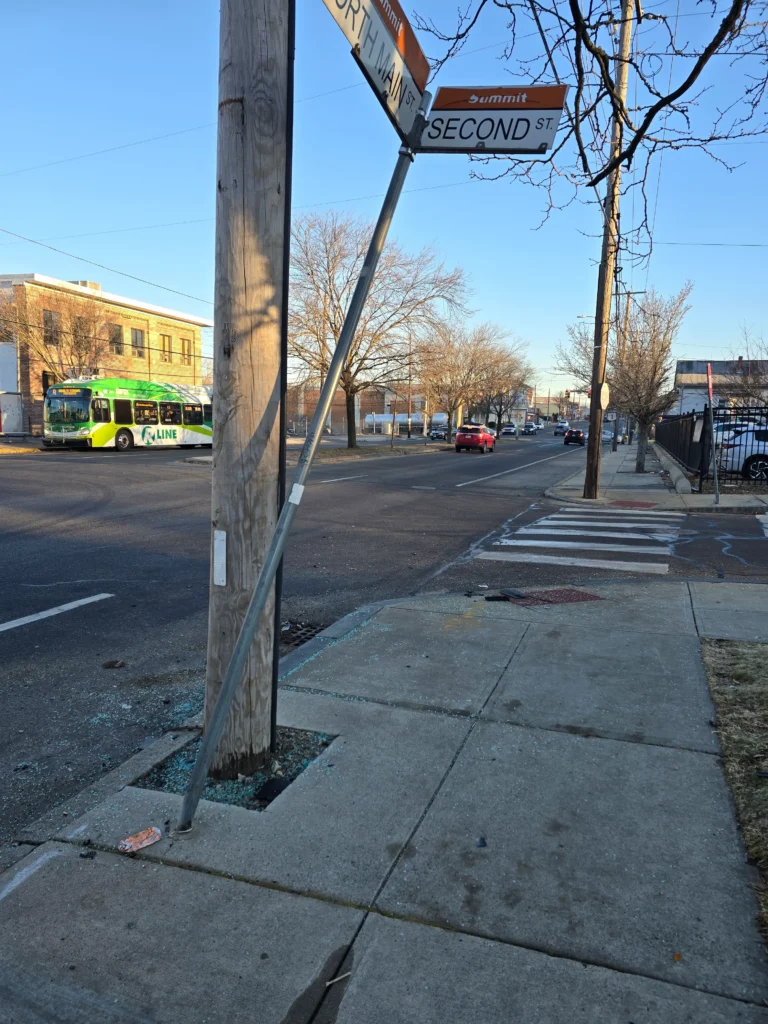 Bent sign and glass on North Main Street's sidewalk.